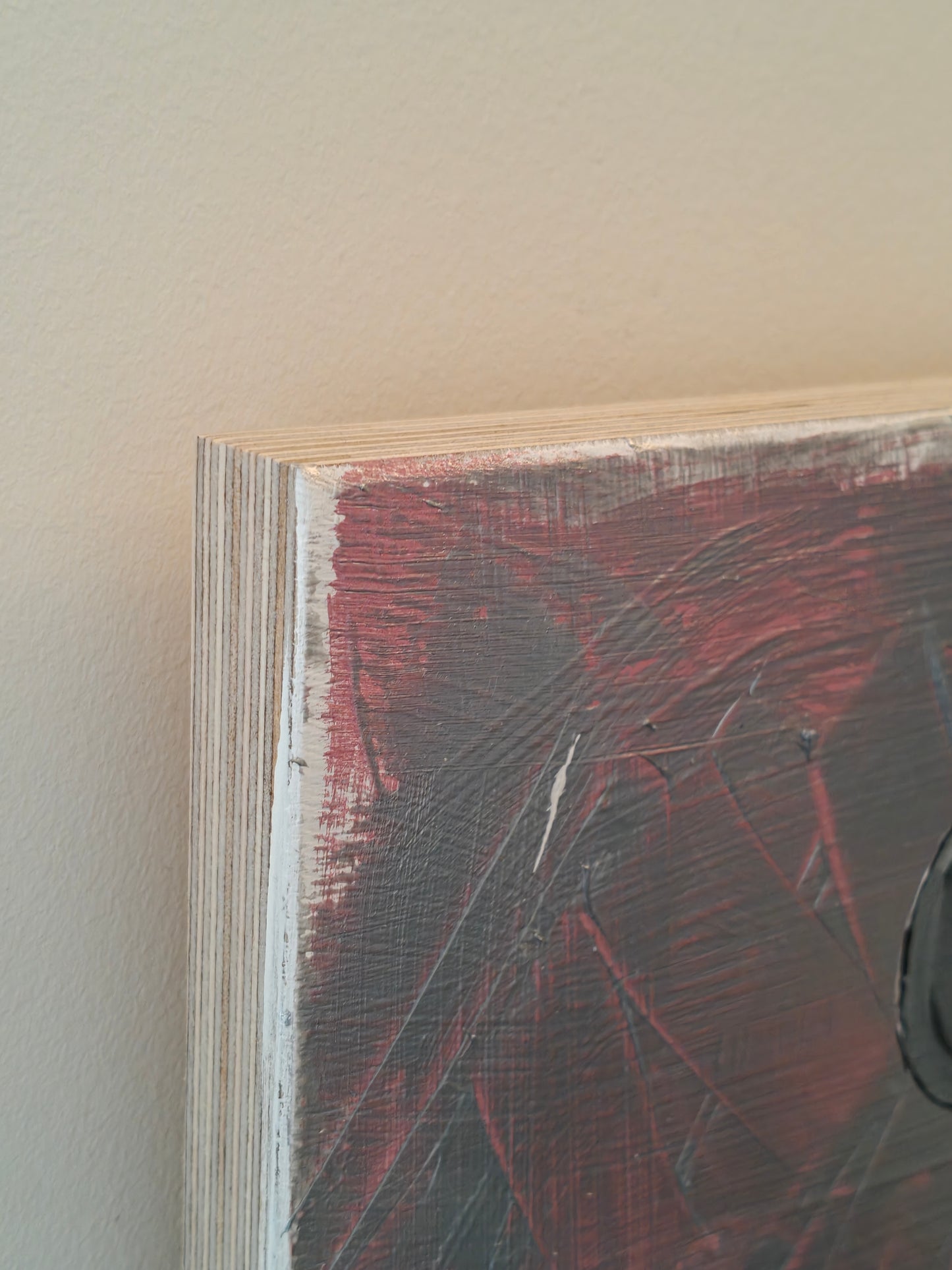Close up of the corner of a Pop art painting of a woman with large flyaway hair and a pink dress with silver spots on. The background of the painting is silver and pink.