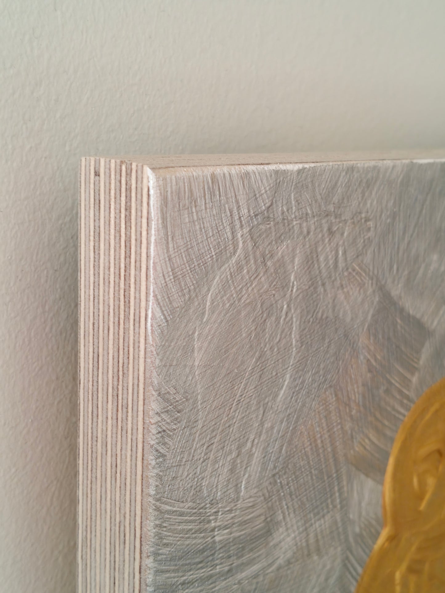 Close up of the corner of an Abstract painting of a stylized woman with golden hair, a spotted dress, and a textured silver background, titled Goldilocks 2.0.