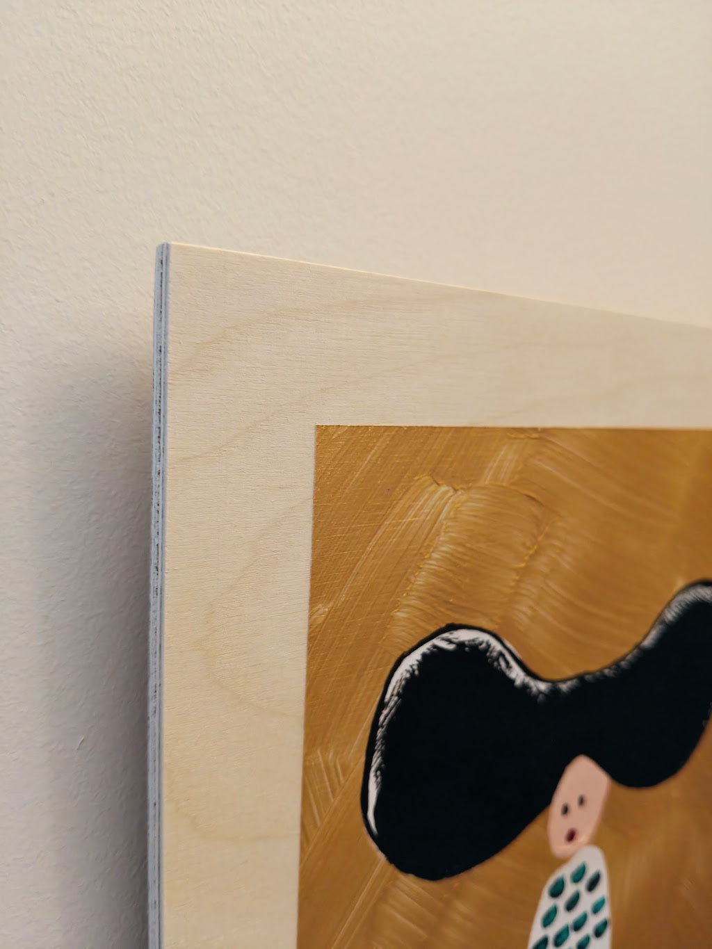 Close up of Acrylic painting on birch plywood depicting a woman with large black hair against a gold backdrop. She's wearing a white dress with green dots.