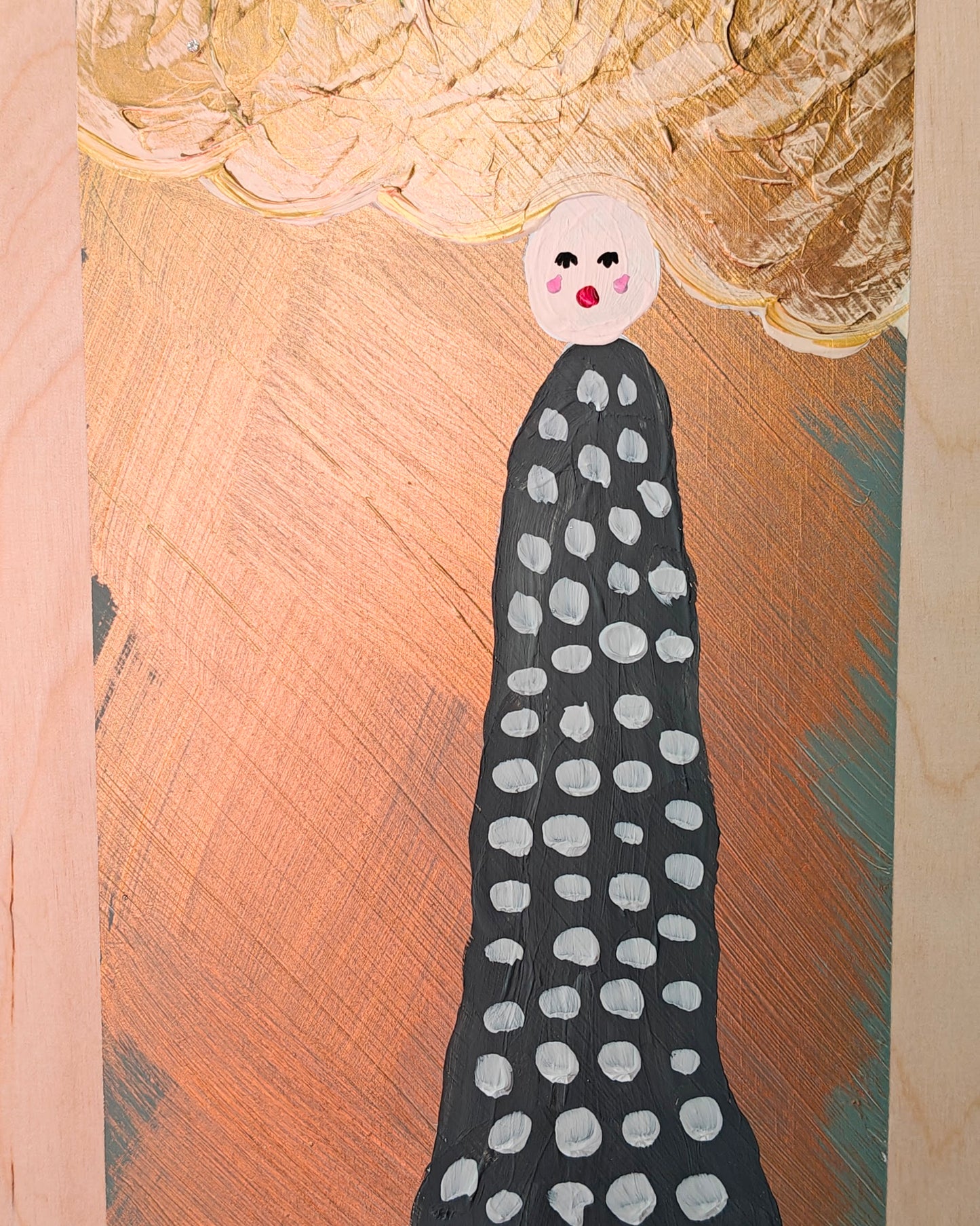 A whimsical painting of a figure with a dotted black dress, a round white head, and large golden cloud-like hair, standing against a gold metallic background with textured cloud-like accents. Painted on light wood.