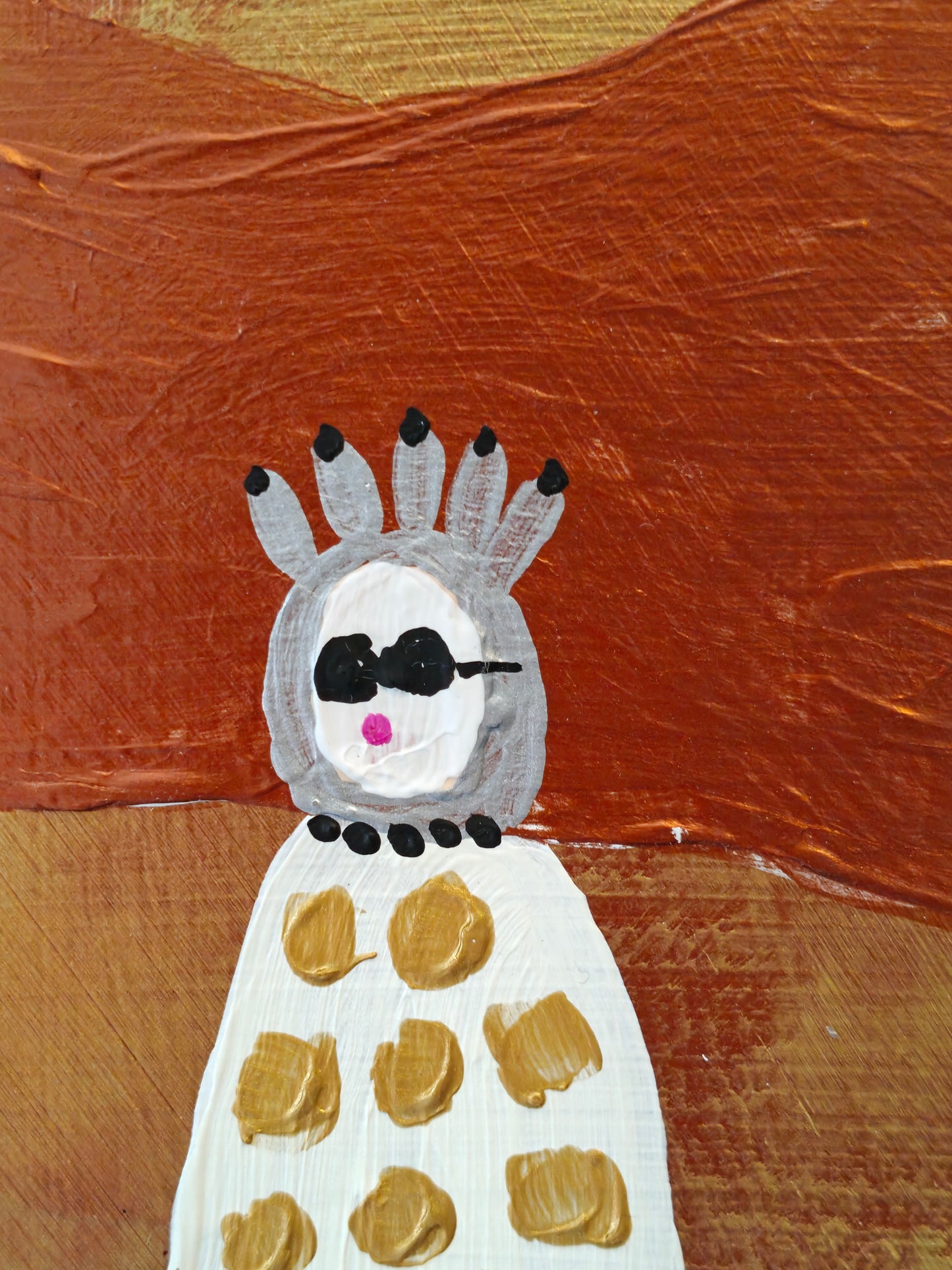 Close up of a Pop art painting of a woman with large flyaway copper hair and a cream dress with gold spots on. The background of the painting is gold and copper. She's wearing sunglasses and a silver headdress or is it a tiara perhaps?