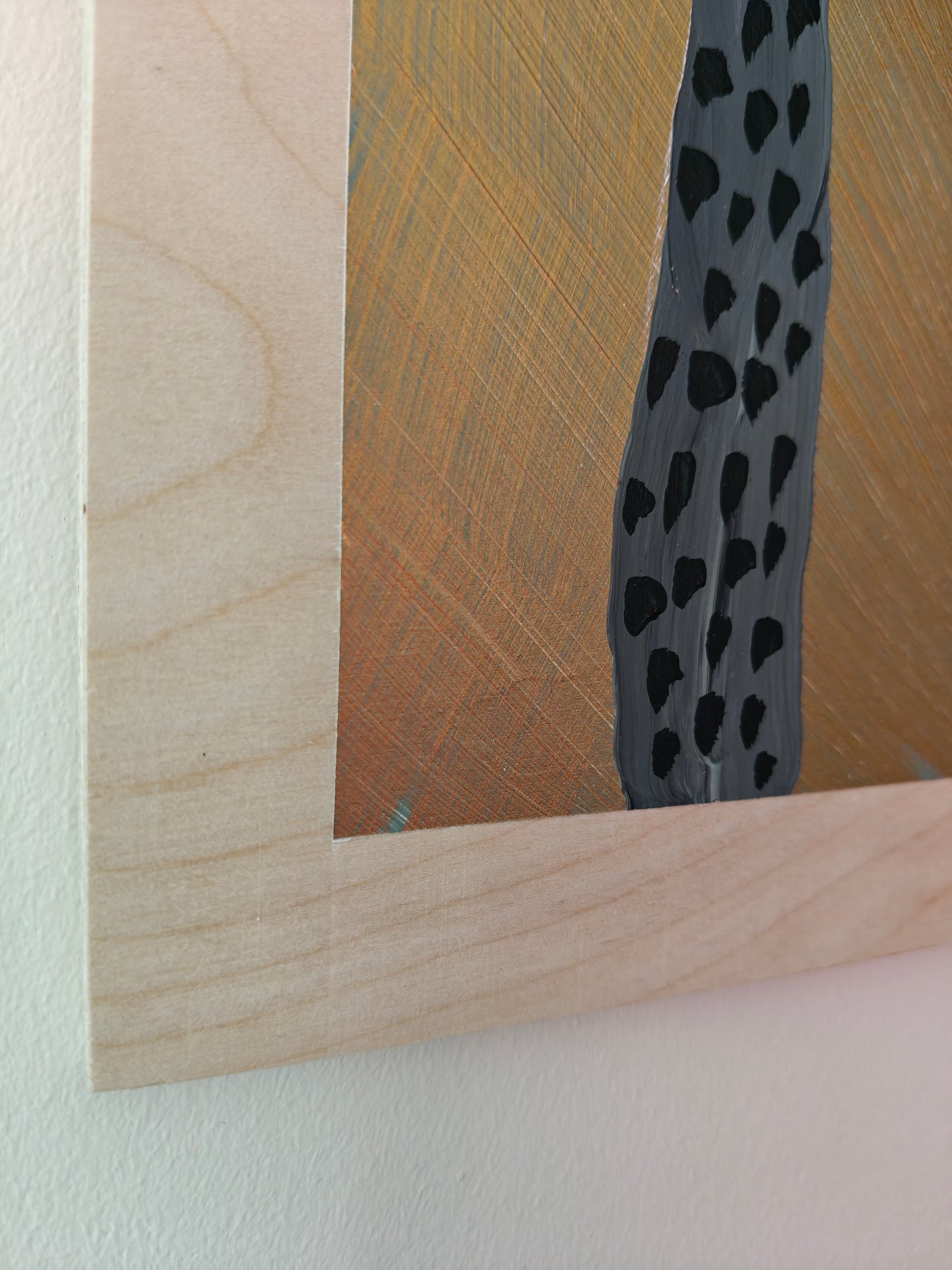 Detail of a painting featuring two tall, abstract figures with dotted bodies and round, expressive faces. The background has a metallic copper tone, contrasting with the natural plywood that the image has been painted on. Part of the Life in Colour collection.