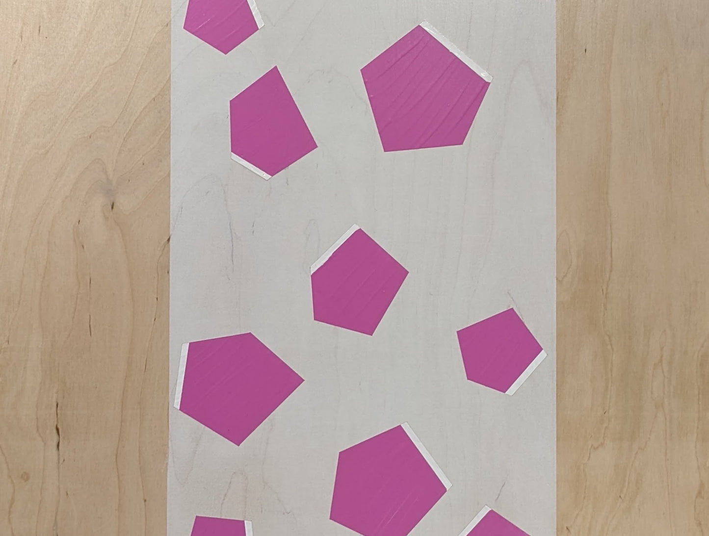 Plywood coffee table with hand-painted unique design in white and pink. Top view. 