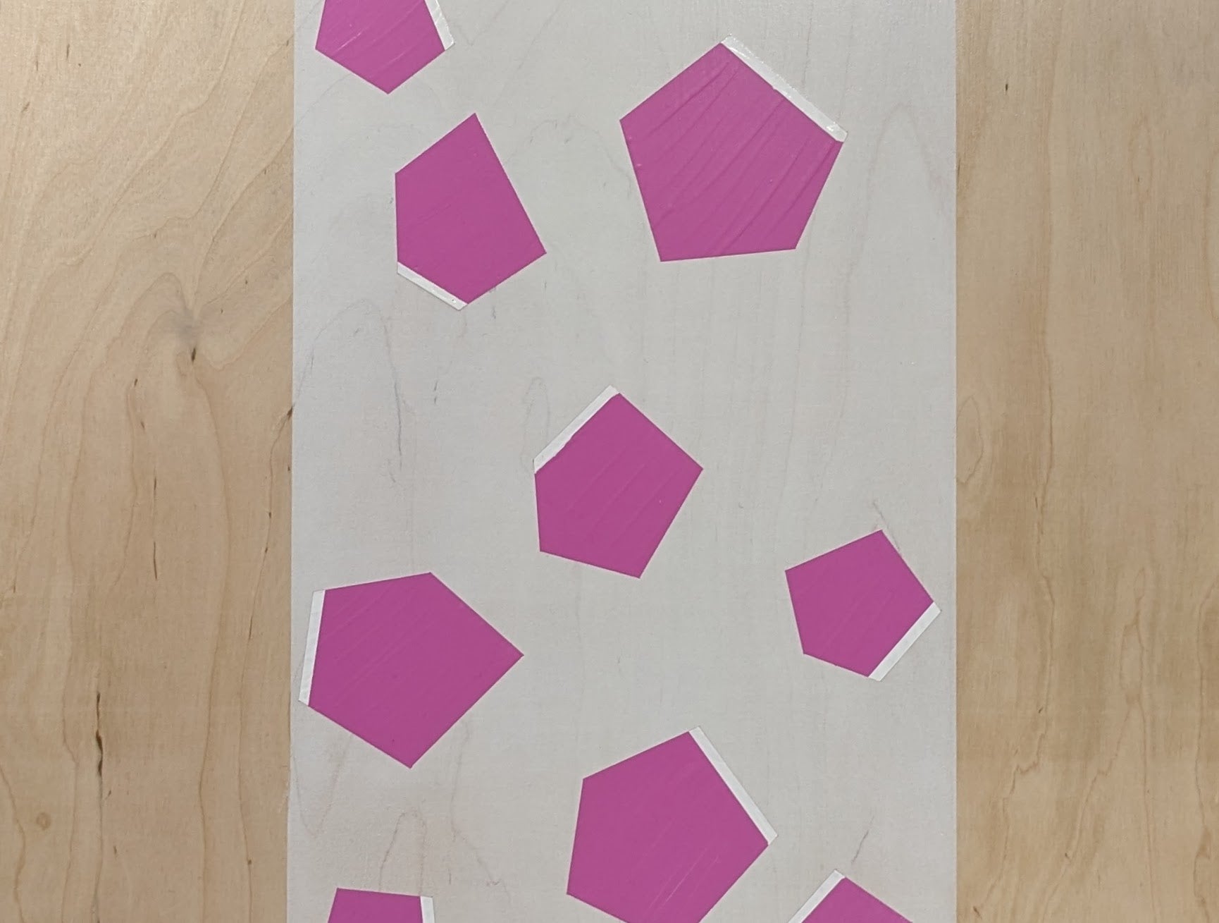Plywood coffee table with hand-painted unique design in white and pink. Top view. 